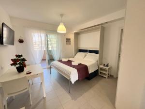 a bedroom with a bed and a table and a desk at La Maison de Marcelle in Tropea