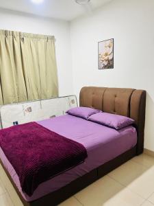 a bed with purple sheets in a room at JC COZYsTAY RAWANG in Rawang +8 photos