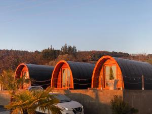 an orange building with a black roof and some cars at Triarca Vinum House in Sabrosa