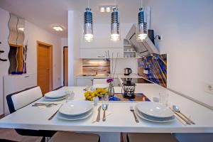 a white dining room table with white plates and silverware at Secret Escape in Rovinj