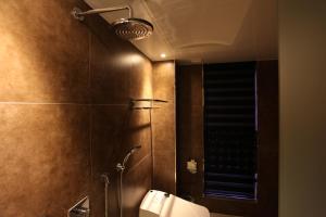 a bathroom with a shower with a toilet and a mirror at Christie Hotel 크리스티 호텔 in Seoul +24 photos