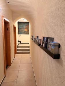 a hallway with a row of books on a wall at AL BOCCALINO Bed & Breakfast Melide Lugano Ticino in Melide