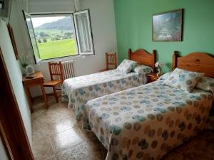 a bedroom with two beds and a window at Posada Gran Sol in Queveda