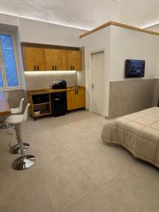 a bedroom with a bed and a table and a kitchen at L'Atrio Suite in Torre del Greco