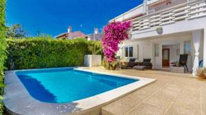 a swimming pool in front of a house at House close to the beach of Punta Prima in Punta Prima