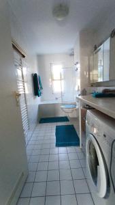 ein Badezimmer mit Waschmaschine und Badewanne in der Unterkunft FeWo Wölfer in Velten + 2 Fotos