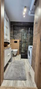 a bathroom with a shower and a washing machine at Izzy Apartament in Myślenice +59 photos