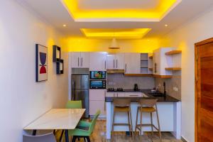 a kitchen with yellow ceilings and a table and chairs at T-Stone Apartments Hotels -Kigali in Kigali