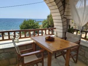 a wooden table with a bowl of fruit on a balcony at Almyra apt in Mani in Kotrónion
