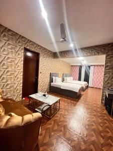 a living room with two beds and a coffee table at Royal Confort Inn in Karachi