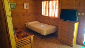 a small room with a bed in a log cabin at Bungalows y Glamping Medina Sidonia in Medina Sidonia