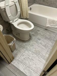 a bathroom with a toilet and a bath tub at Bragg Motel in Upper Marlboro