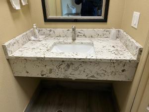 a marble counter top with a sink in a bathroom at Bragg Motel in Upper Marlboro +3 photos