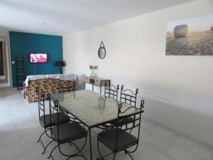 a dining room with a glass table and chairs at La maison du Lac in Louin