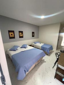 a bedroom with two beds with blue pillows at Hotel Acqua Park in Capim Grosso +7 photos