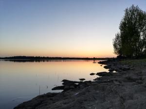 a sunset over a lake with birds in the water at La maison du Lac in Louin