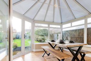 a dining room with a table and windows at Drovers Way, Worcester in Fernhill Heath