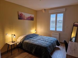 a bedroom with a bed and a window at La maison du Lac in Louin