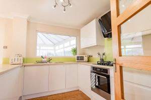 a kitchen with white cabinets and a window at Drovers Way, Worcester in Fernhill Heath +35 photos