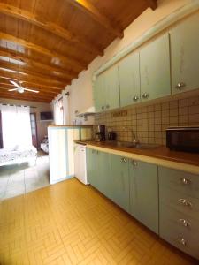 a kitchen with green cabinets and a wooden floor at Almyra apt in Mani in Kotrónion +17 photos