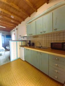a kitchen with green cabinets and a sink in it at Almyra apt in Mani in Kotrónion