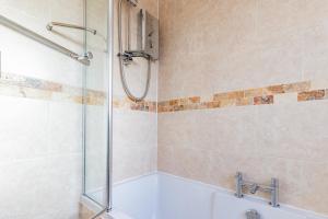 a bathroom with a shower with a tub and a sink at Drovers Way, Worcester in Fernhill Heath