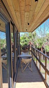a wooden porch with a table and chairs on it at Bungalows y Glamping Medina Sidonia in Medina Sidonia