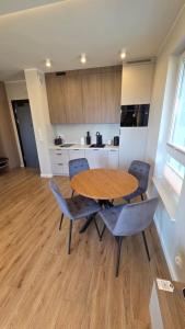 a kitchen with a wooden table and chairs in a room at Wyspa9 - Gdańsk Wyspa Sobieszewska in Gdańsk