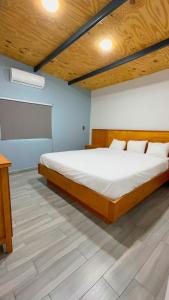 a bedroom with a large bed with a wooden ceiling at Hotel Luz de Luna y Villas in San Jerónimo