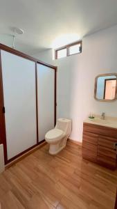 a bathroom with a toilet and a sink and a mirror at Hotel Luz de Luna y Villas in San Jerónimo