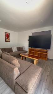a living room with a couch and a large flat screen tv at Hotel Luz de Luna y Villas in San Jerónimo