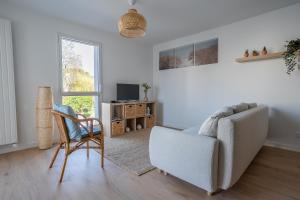 a living room with a couch and a chair at L'Escale d'Erdeven - En centre-bourg in Erdeven