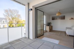 a living room with a large sliding glass door at L'Escale d'Erdeven - En centre-bourg in Erdeven +8 photos