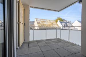 an empty balcony with a view of a house at L'Escale d'Erdeven - En centre-bourg in Erdeven