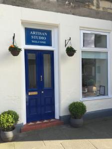 a building with a blue door and a window at Artisan Studio in Tarbert