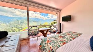 a bedroom with a bed and a balcony with a view at Hotel El Mirador del Cocora in Salento +130 photos