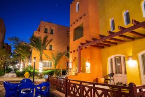 a building with blue chairs outside of it at night at Al Dora Hotel & Spa in Hurghada