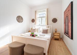 a bedroom with a white bed with two stools at Celine Prague Luxury Hostel in Prague +53 photos