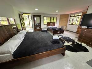 a large bedroom with two beds and a flat screen tv at Finca Jamaica in Circasia