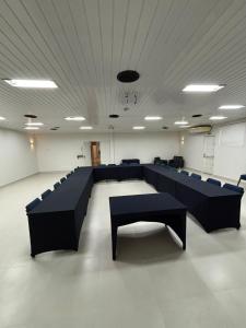 a conference room with black tables and blue chairs at Rio Claro Plaza Hotel in Rio Claro +34 photos
