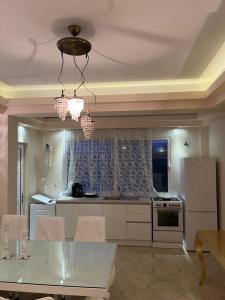 a kitchen with a table and a refrigerator and a table and chairs at Ria Villa Preveza in Kalamitsi