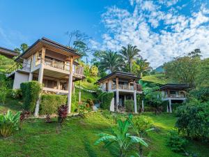 a row of houses on a hill with trees at Tiki Villas Rainforest Lodge - Adults Only in Uvita