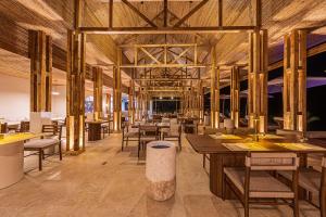 a restaurant with wooden floors and tables and chairs at Tiki Villas Rainforest Lodge - Adults Only in Uvita