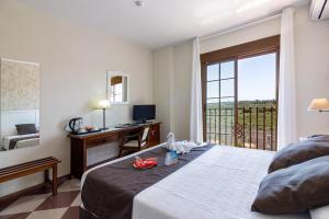 a bedroom with a bed and a desk and a window at Hotel Avenida Tropical by Bossh! Hotels in Salobreña +102 photos