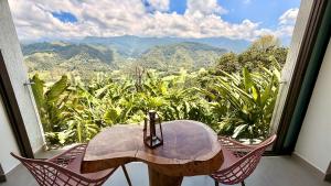 a table and chairs with a view of the mountains at Hotel El Mirador del Cocora in Salento