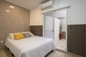 a bedroom with a white bed and a window at Departamento Moderno, equipado en Vicente Lopez , Ideal River Plate ,Tecnópolis ,100 metros del tren in Vicente López