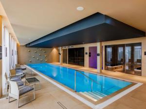 a large swimming pool in a building at Movenpick Hotel Tallinn in Tallinn