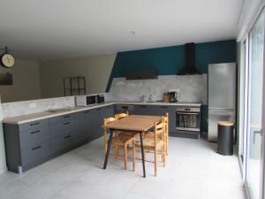 a kitchen with a wooden table and blue cabinets at La maison du Lac in Louin