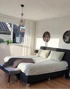 a bedroom with a large bed and a window at Onder de Beukenboom in Nieuwe Pekela