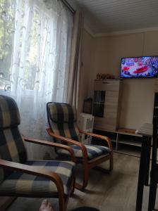 a living room with two chairs and a television at Apartment Temo in Ureki